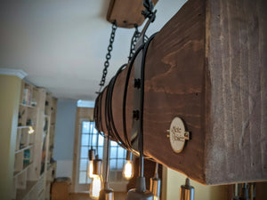 Luminaire de style farmhouse avec poutre de bois ceinturée d'acier.